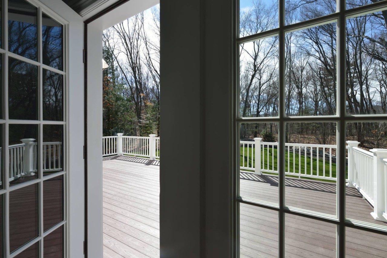 View through an open French door of a deck, yard, and woods near Dayton, Ohio (OH)